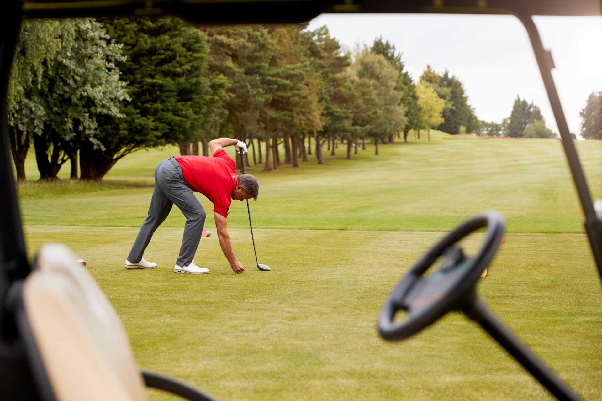 Golfer teeing up a ball on a British golf course